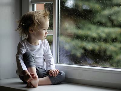 A baby girl sitting on the sill.