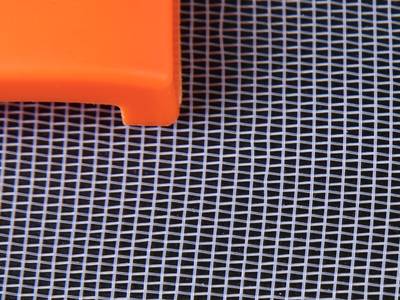 An orange object on the plain weave white color plastic insect screen.