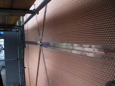 Copper expanded metal screens are installed as the wall of house.