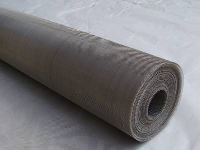 A roll of stainless steel shielding mesh on the gray background.