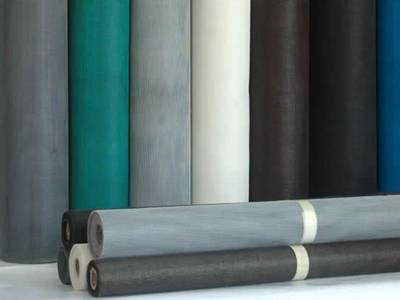 Several rolls of fiberglass wire screen in different colors.